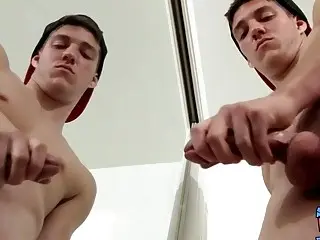 Jock strips in front of a mirror and jerks off